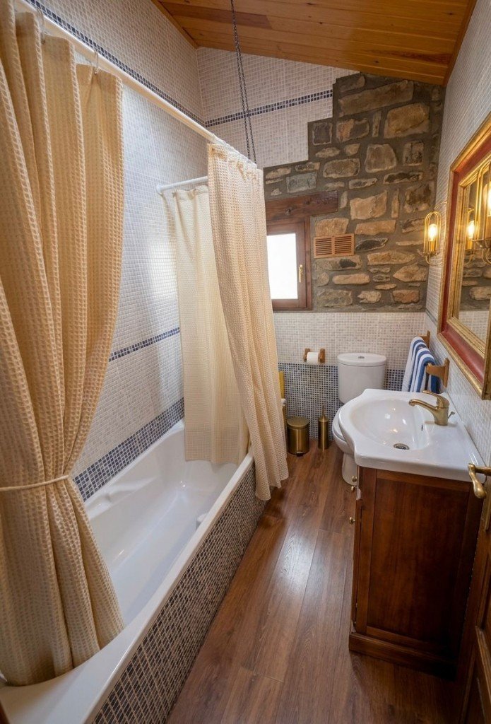 Baño con bañera y techo de madera